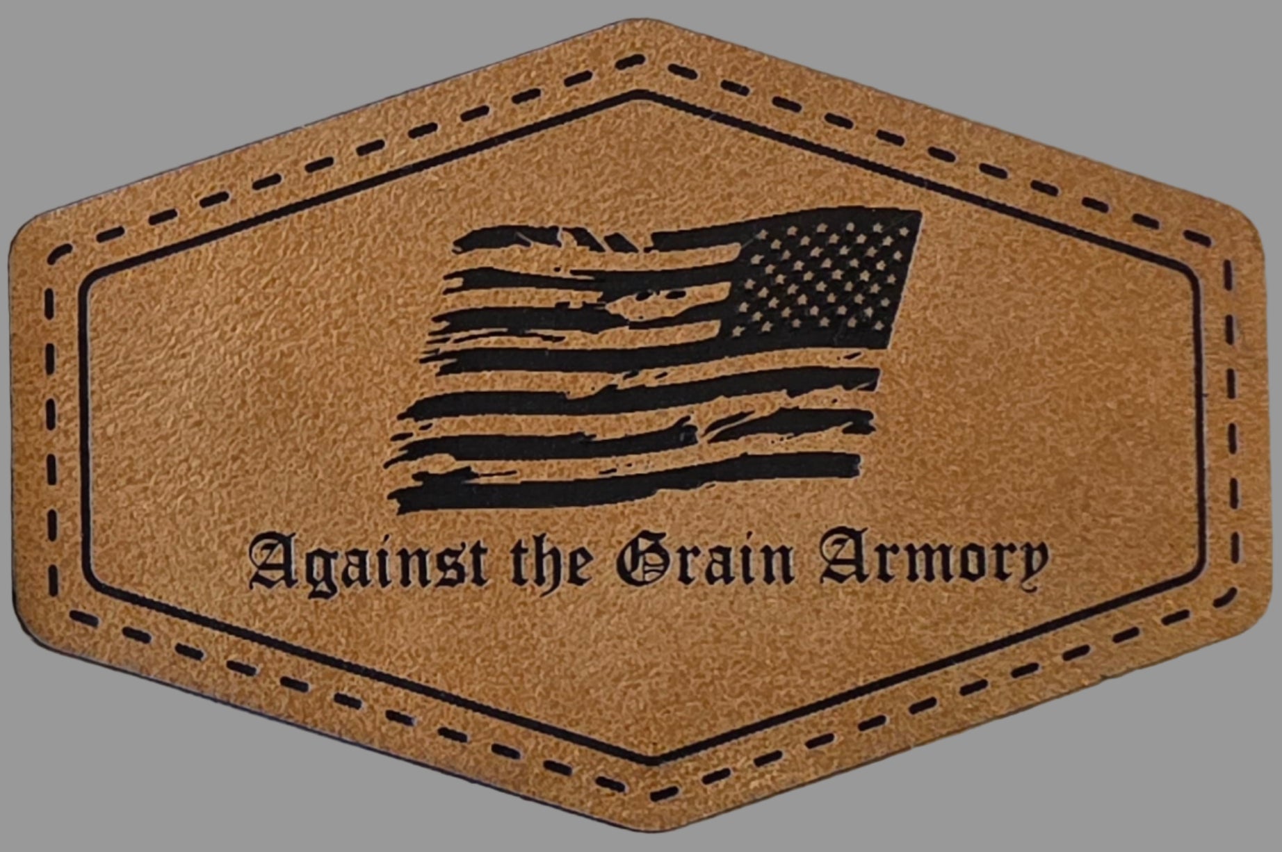 A leatherette patch with American flag design and 'Against the Grain Armory' branding.